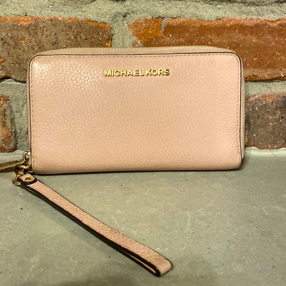 Michael Kors light pink wristlet wallet. gold zipper closure.